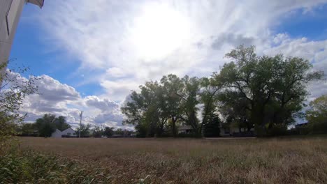 timelapse - across a field in a small town near alberta canada on a cloudy day during the daytime