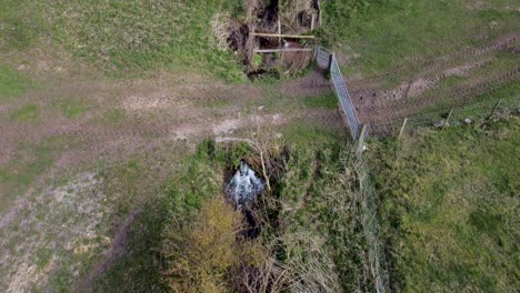 Vista-Aérea-De-Un-Dron-De-Un-Arroyo-Con-Un-Prado