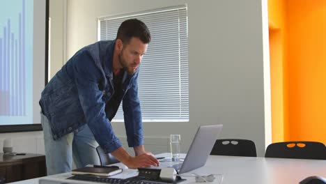 Male-executive-using-laptop-in-conference-room-4k