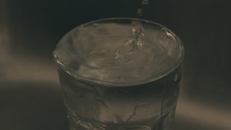 el agua cae en un vaso en cámara lenta detalle del vaso
