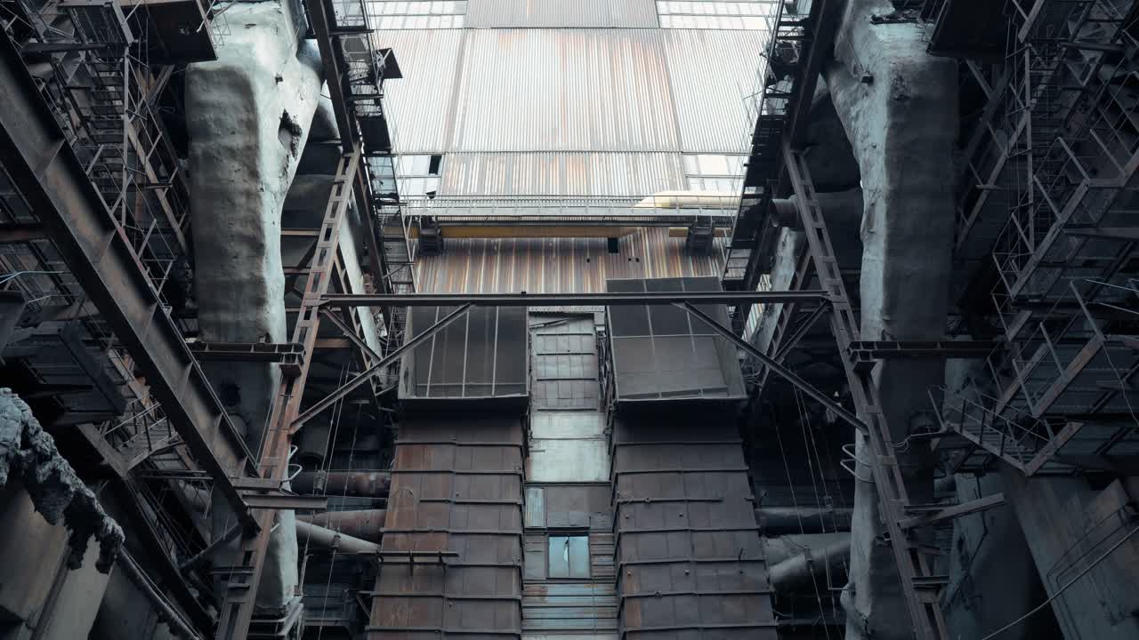 Post-apocalyptic view of an abandoned factory with huge rusty metal pipes and structures. Destroyed coal power plant. Old industrial area