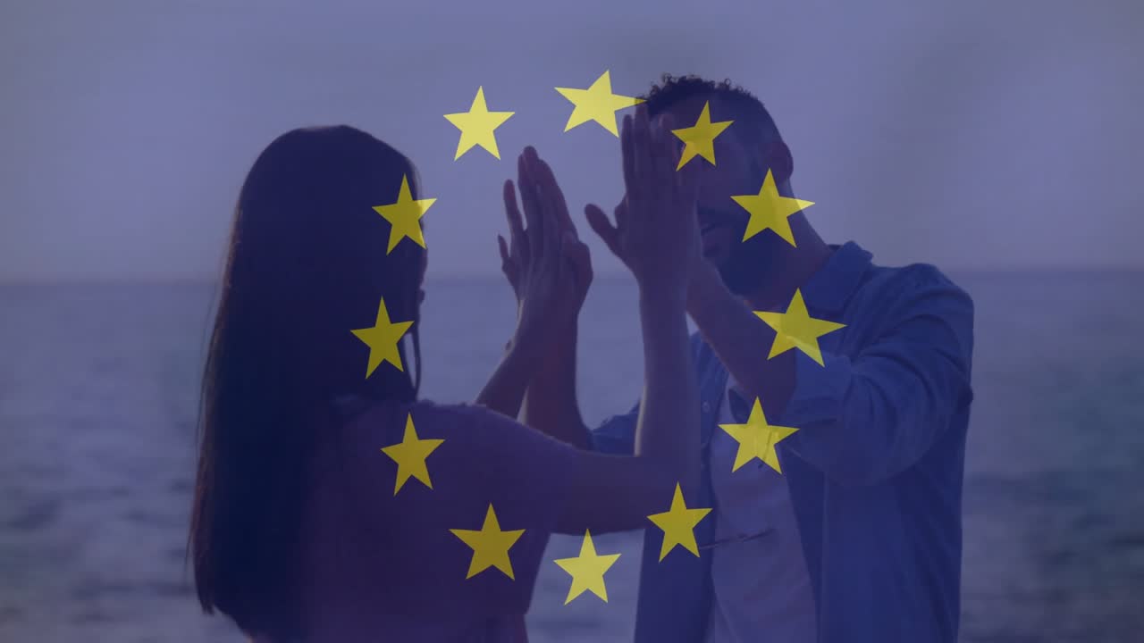 Pareja abrazándose junto al océano, con una superposición de estrellas de la Unión Europea en animación.