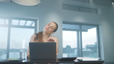 mujer de negocios estirando los brazos. mujer cansada relajándose en un lugar de trabajo remoto.