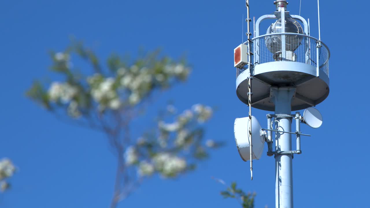 Static shot of a telecommunications tower top against a clear blue sky in Canberra