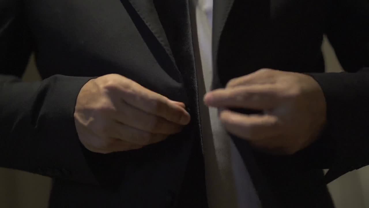 결혼식 의상을 입은 남자가 우아하고 기대하며 특별한 날을 준비하는 순간을 포착하십시오.