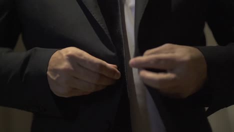 capturar el momento de un hombre vistiendo su traje de boda, preparándose para su día especial con elegancia y anticipación