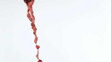 animation of burning paper over red wine on white background