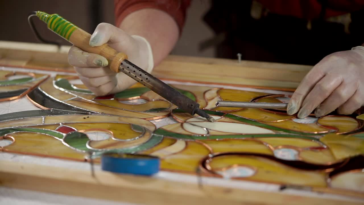 스테인드 글래스 예술가 가 미술 작품 을 작업 하고 있다