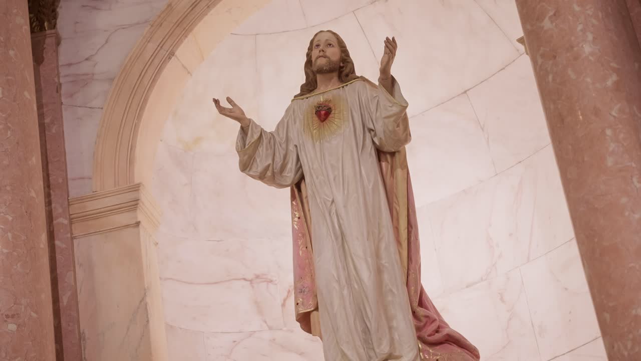 Estatua religiosa de Jesucristo con el Sagrado Corazón en una iglesia de mármol