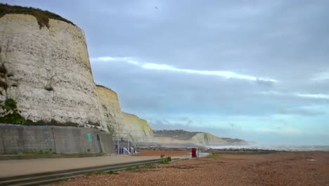 Vista-A-Lo-Largo-De-La-Playa-De-Guijarros-En-Rottingdean,-Inglaterra,-A-Lo-Largo-De-La-Costa-Y-Los-Acantilados-Blancos-De-Dover