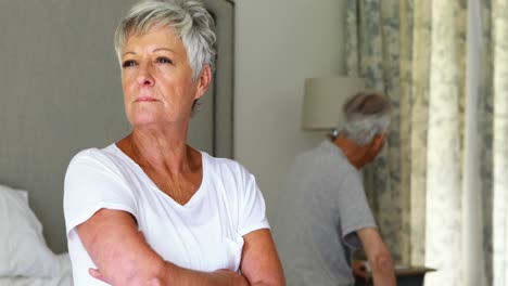 upset senior couple arguing with each other in bedroom