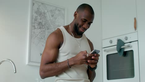 man using phone in kitchen
