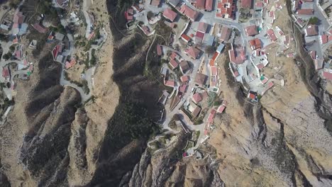 Vista-Aérea-Aérea-De-Un-Antiguo-Pueblo-Español-Cerca-De-Una-Gran-Montaña-En-El-Desierto