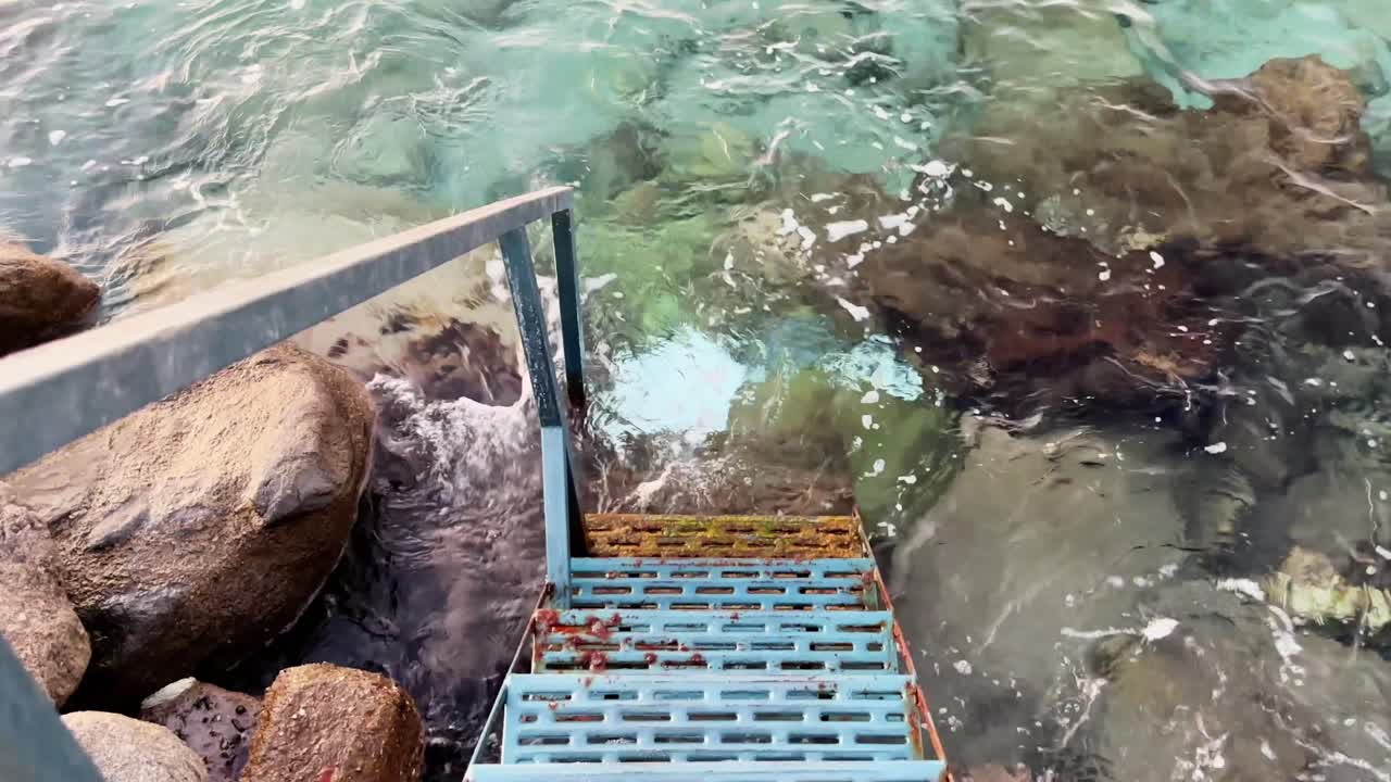 Steps descending from a rocky shore into the clear Mediterranean waters, Kos, Greece