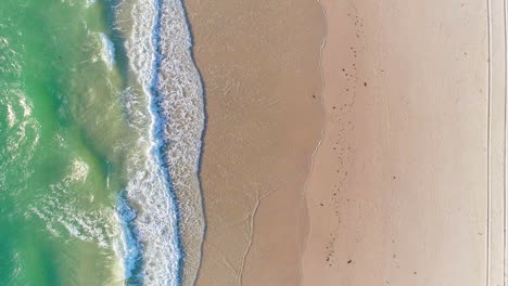 Waves-gently-crashing-onto-a-beach-in-Tennyson-in-Adelaide,-South-Australia