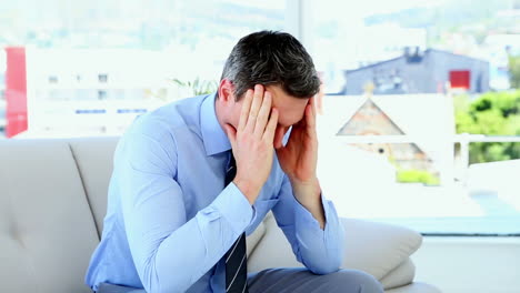 Worried-businessman-sitting-on-sofa