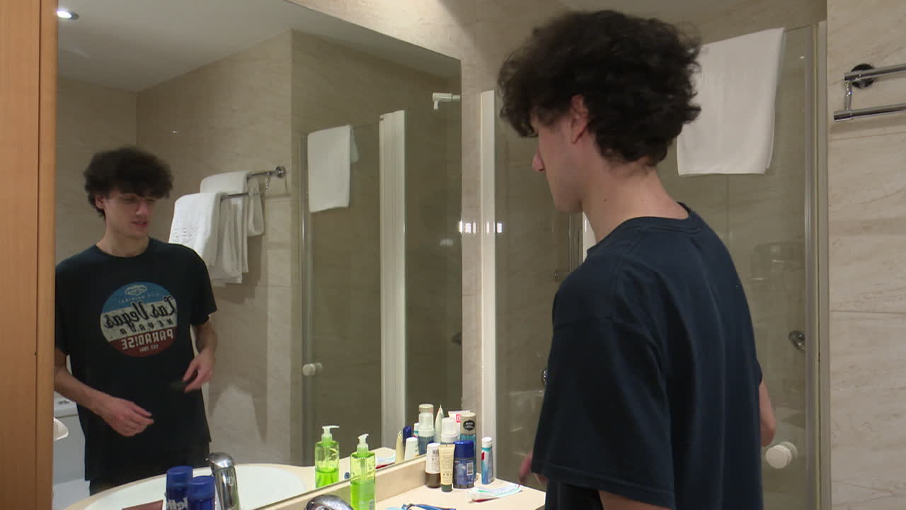 Young Man Grooming in Hotel Bathroom