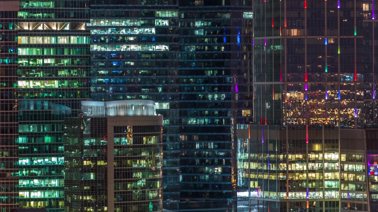 Modern office building with glowing windows at night timelapse. Moscow city. Close up view from rooftop