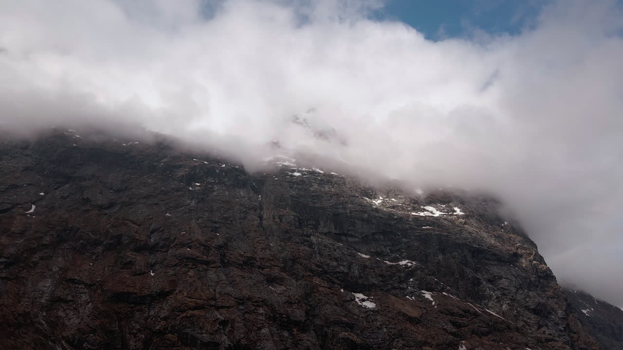 Looking up towards the mountain peak that is covered with clouds
