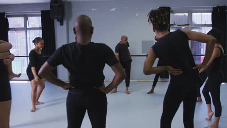 grupo multiétnico de bailarines modernos en forma masculinos y femeninos practicando una rutina de baile