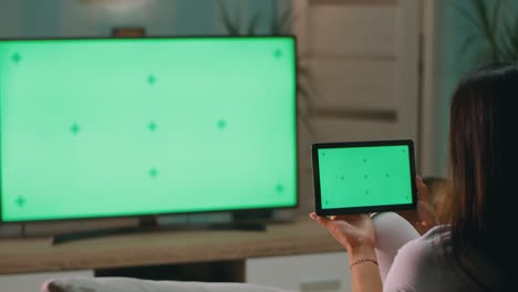 anonymous mother browsing tablet near tv