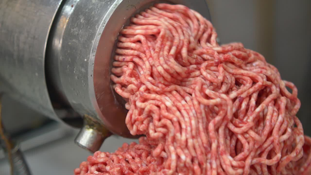 Ground meat being processed by a meat grinder