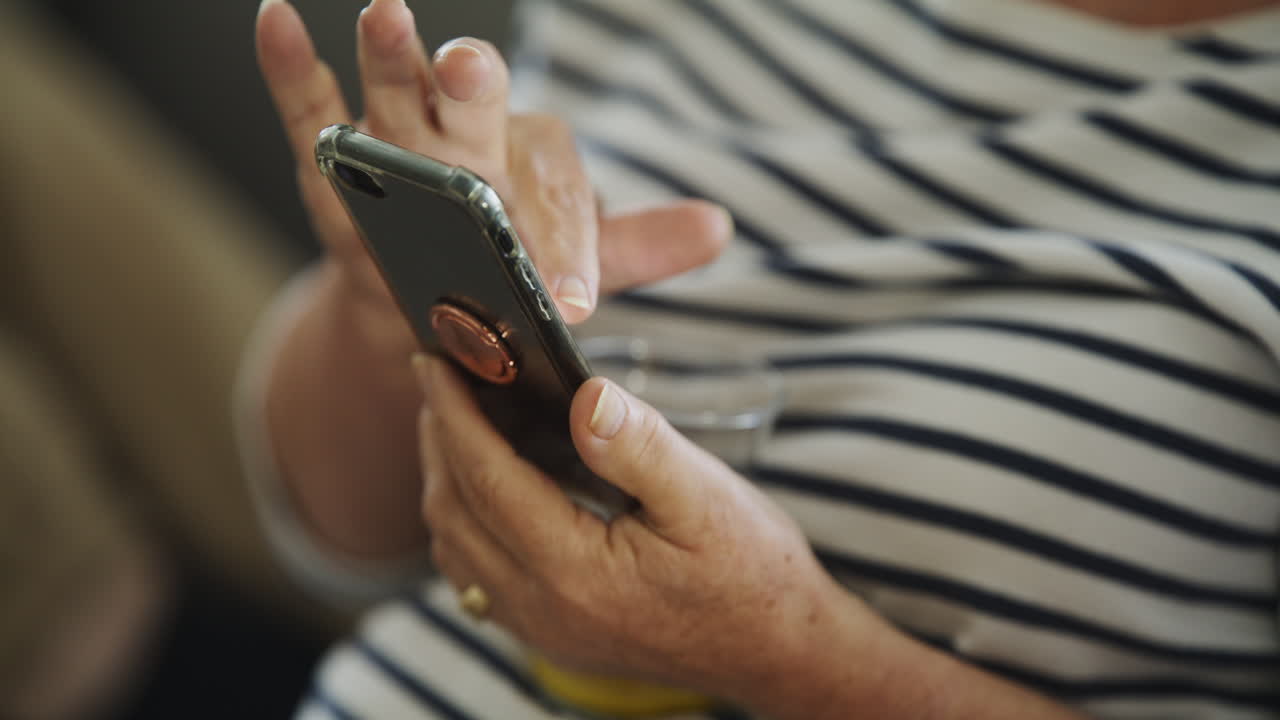 La anciana usando el teléfono inteligente