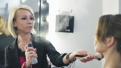 esteticista aplicando spray en el rostro de la mujer, cámara lenta. primer plano de esteticista hidratando la piel de la niña con spray