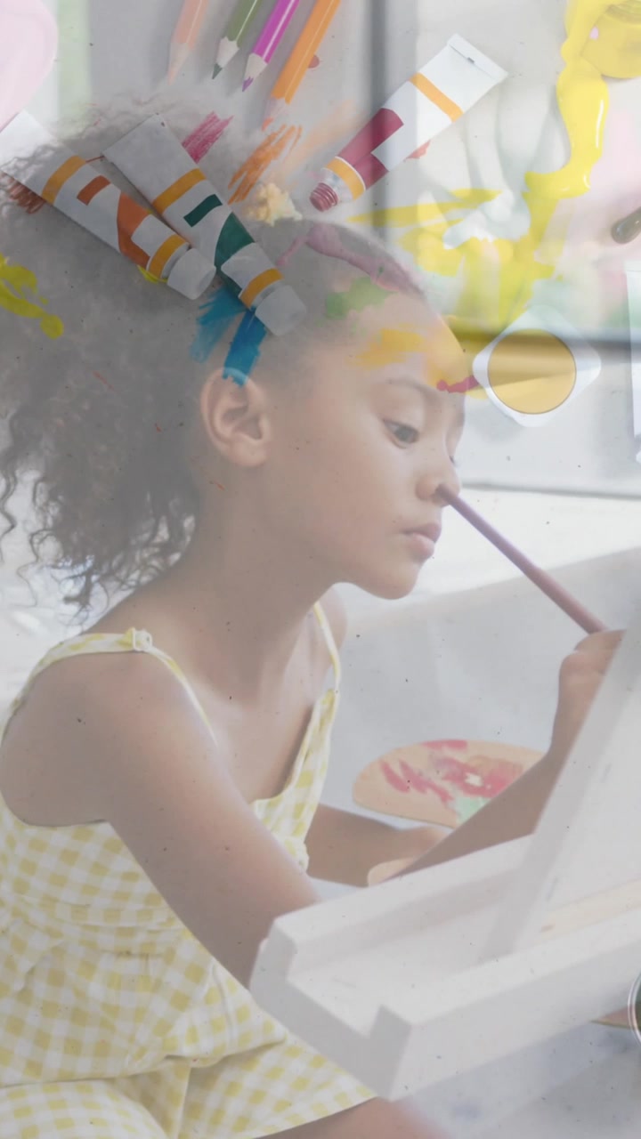 Animation of art equipment over happy diverse schoolgirls painting in art class