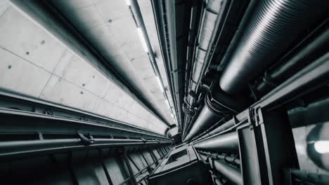 view up an elevator shaft with industrial machinery and pipes