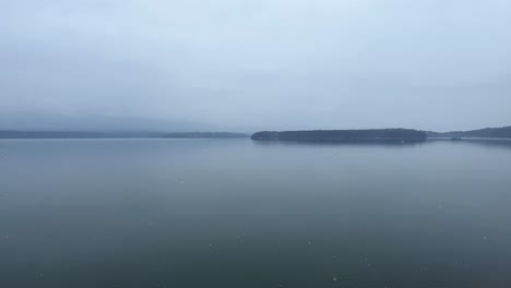 Beautiful-snowy-day-over-a-still,-calm-Mountain-Lake---slow-motion