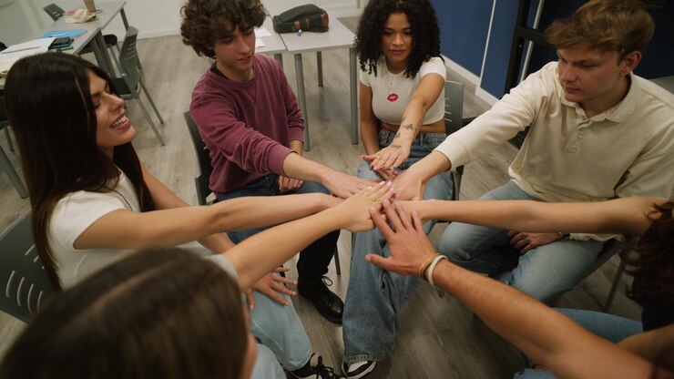Grupo de jóvenes uniendo manos en círculo para la unidad