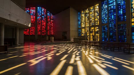 stunning interior of a modern sanctuary with vibrant stained glass windows casting colorful shadows on the floor, illuminating the sacred space with warm light and spiritual atmosphere