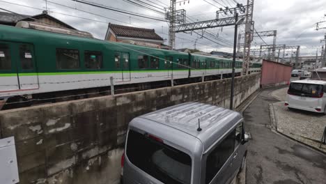 a train moves through a cityscape alongside cars.