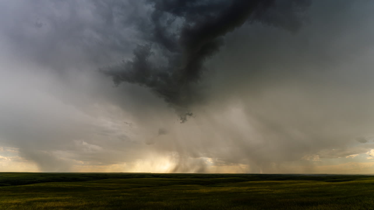 Heavy rain bands clear to reveal sunset colors below a stormy sky