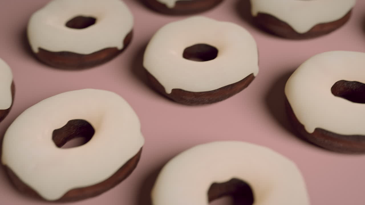 White glaze donuts on a light pink background