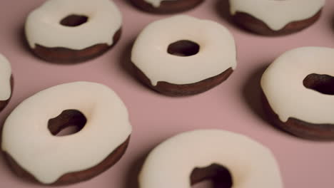 white glaze donuts on a light pink background