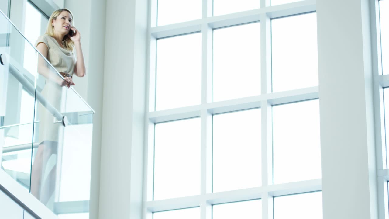 белая бизнесменка использует смартфон в городском офисе