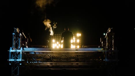 silueta de un luchador en el escenario con humo y luces