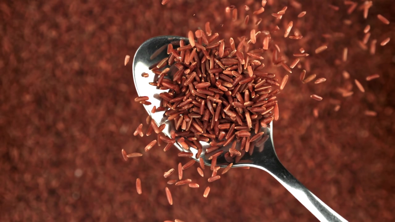 Slow Motion of Red Rice Grains Falling on a Spoon