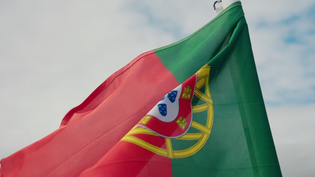 Close-up da bandeira portuguesa tremulando na popa do barco.