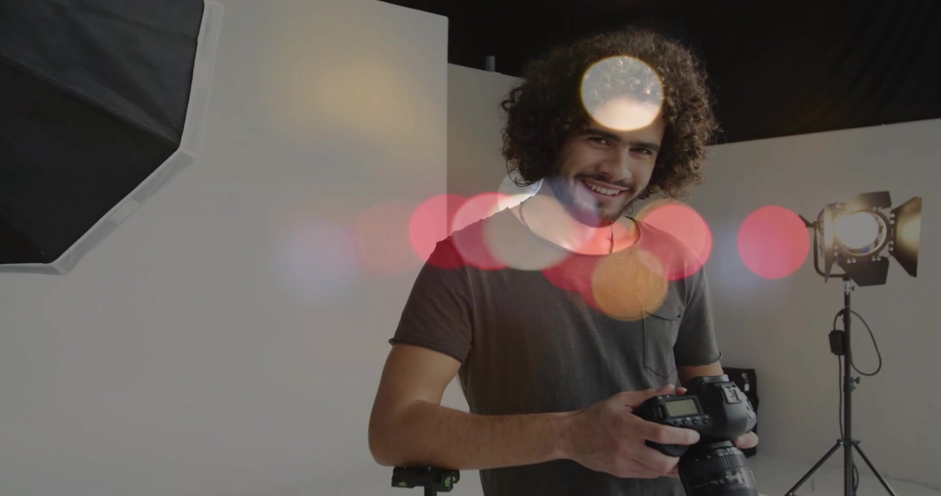 Operatore di ripresa che inquadra una DSLR e allinea l'obiettivo sul treppiede per la preparazione di uno shooting in studio