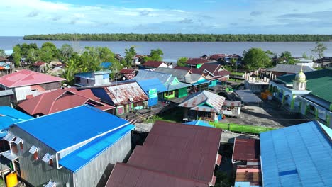 häuser und moscheen der bewohner mit blick auf einen breiten fluss, einen dichten wald und einen wunderschönen blauen himmel in asmat, papua, indonesien