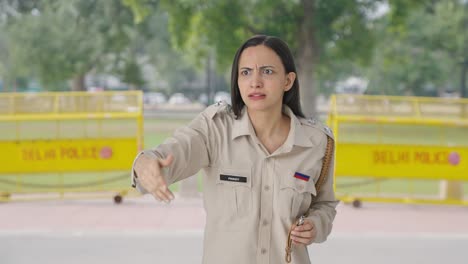 angry indian female police officer using whistle to call someone