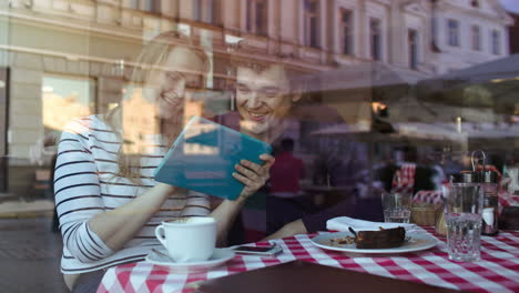 happy young couple with tablet pc in a cafe