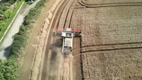 Aerial-footage-of-a-combine-harvester-and-tractor-harvesting-a-wheat-crop