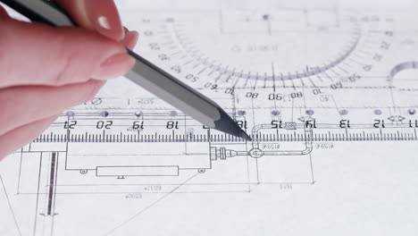 close-up of a hand using a pencil and ruler on a technical drawing