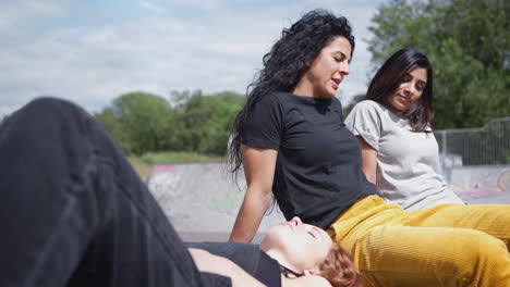 Drei-Freundinnen-Treffen-Sich-Und-Entspannen-Sich-Im-Städtischen-Skatepark