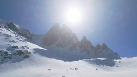 alpinistas caminando por un valle nevado en la cadena montañosa de lagorai