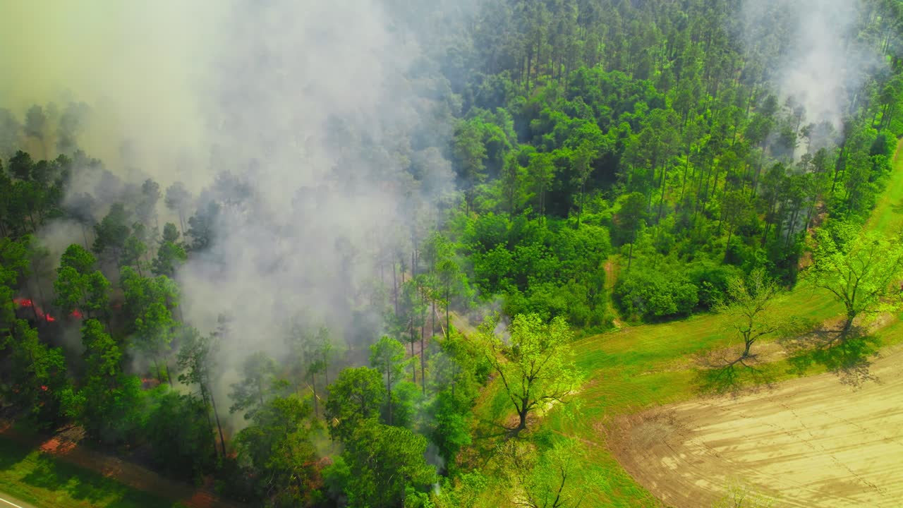 Orbiting Aerial Drone Footage of Forest Fire Spreading at Property Edge with Billowing Smoke